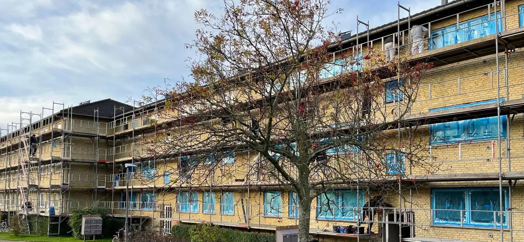 Nybyg og Bolig i gang med en bygningsrenovering under stillads