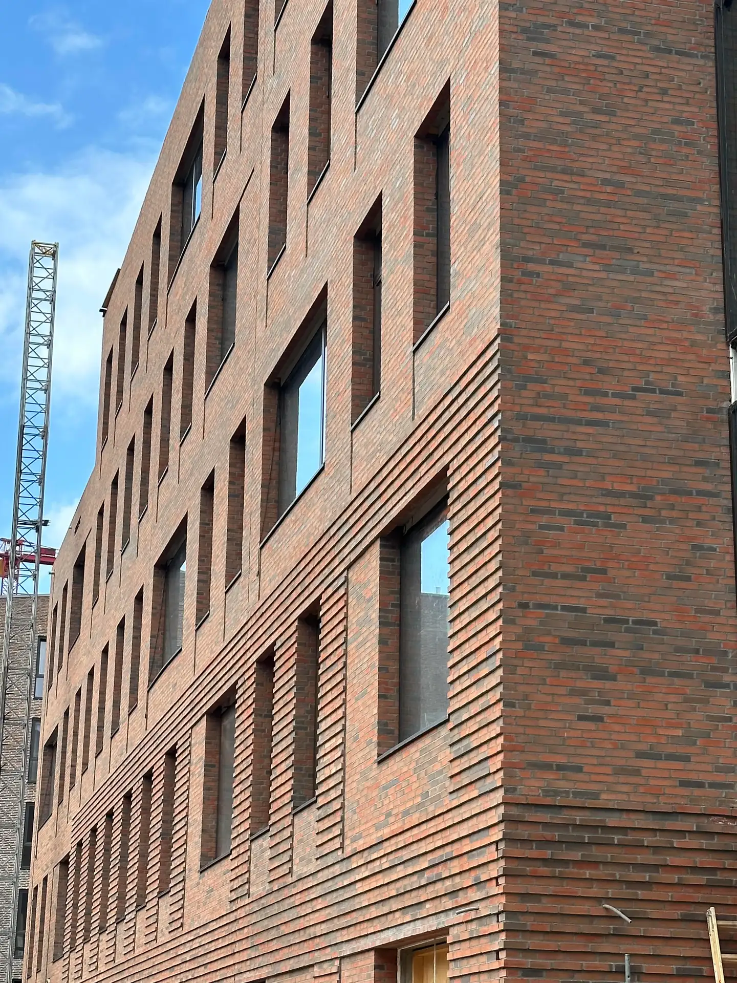 Ny skalmuring med tårnkran i baggrunden